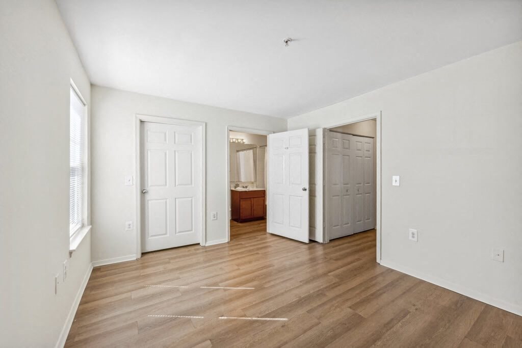 an empty living room with white walls and wood floors